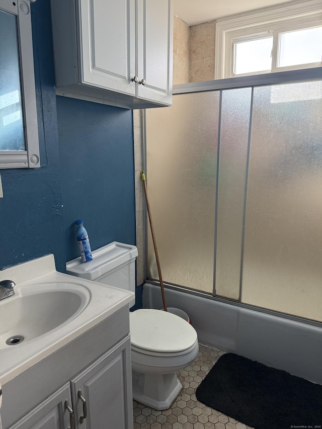 full bathroom with vanity, combined bath / shower with glass door, tile patterned floors, and toilet