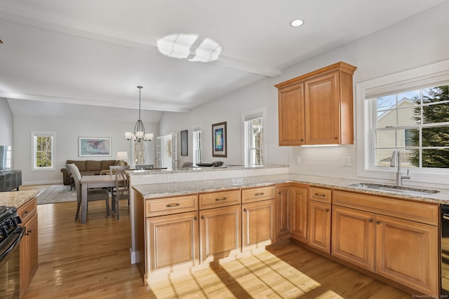 kitchen with beamed ceiling, kitchen peninsula, sink, and light hardwood / wood-style flooring