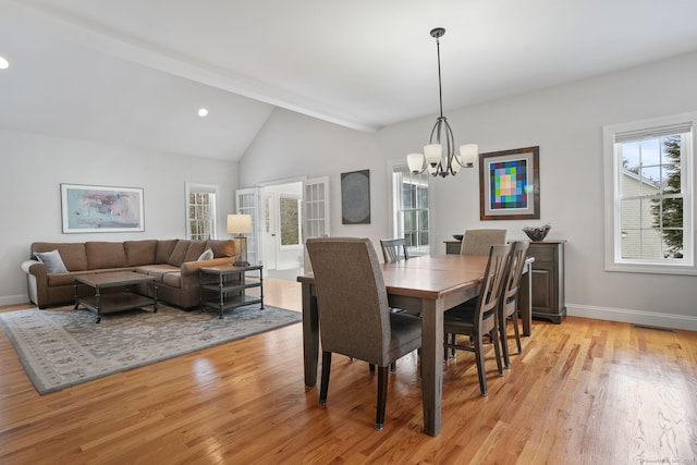 dining room with vaulted ceiling, a chandelier, and light hardwood / wood-style floors