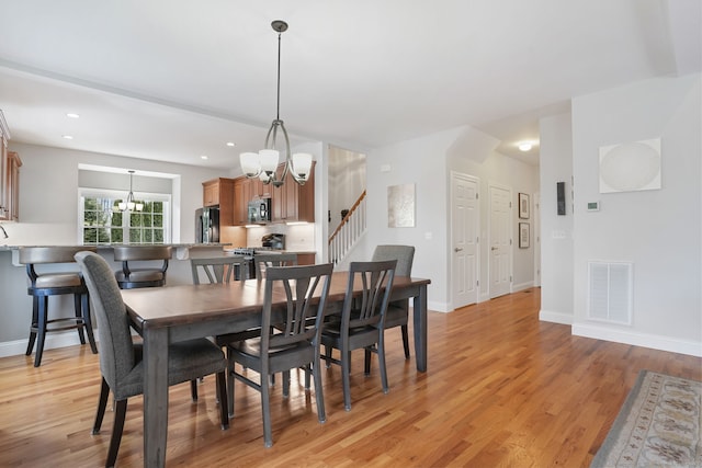 dining room featuring an inviting chandelier and light wood-type flooring