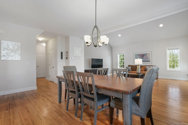 dining area featuring lofted ceiling, a notable chandelier, and light wood-type flooring