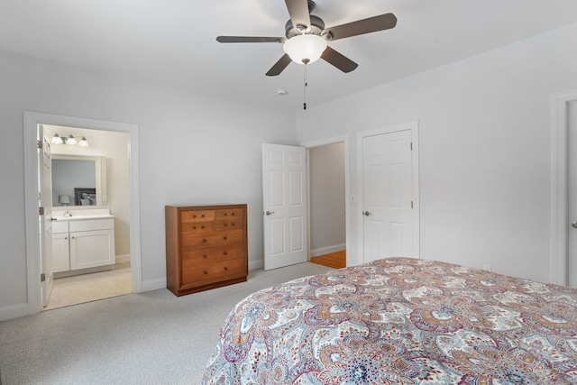 carpeted bedroom with ensuite bathroom and ceiling fan