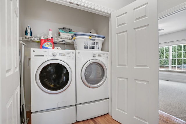 laundry room with washing machine and clothes dryer and light wood-type flooring