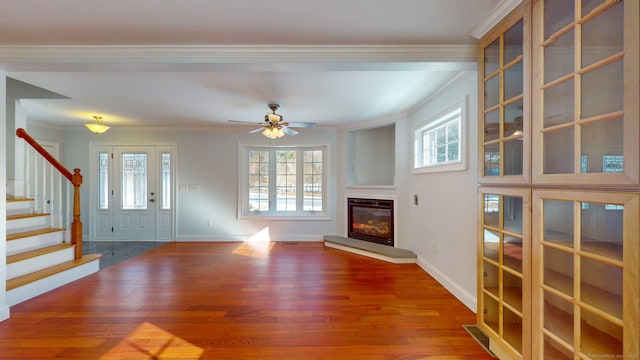 unfurnished living room with hardwood / wood-style floors, crown molding, and ceiling fan