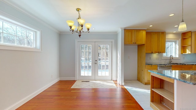 doorway with sink, crown molding, a notable chandelier, light hardwood / wood-style floors, and french doors