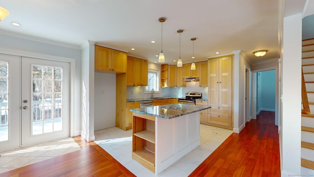 kitchen featuring stone countertops, decorative backsplash, hanging light fixtures, a center island, and stainless steel appliances