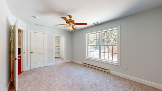 carpeted spare room with ceiling fan and baseboard heating