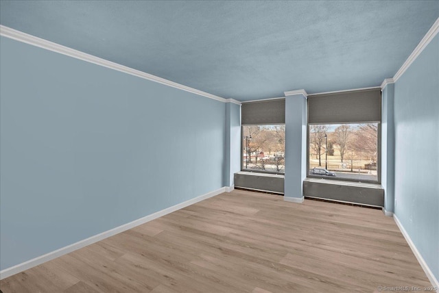 empty room featuring ornamental molding and light hardwood / wood-style flooring