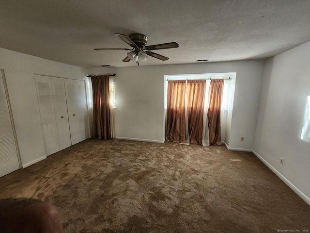 unfurnished bedroom featuring multiple windows, ceiling fan, and carpet