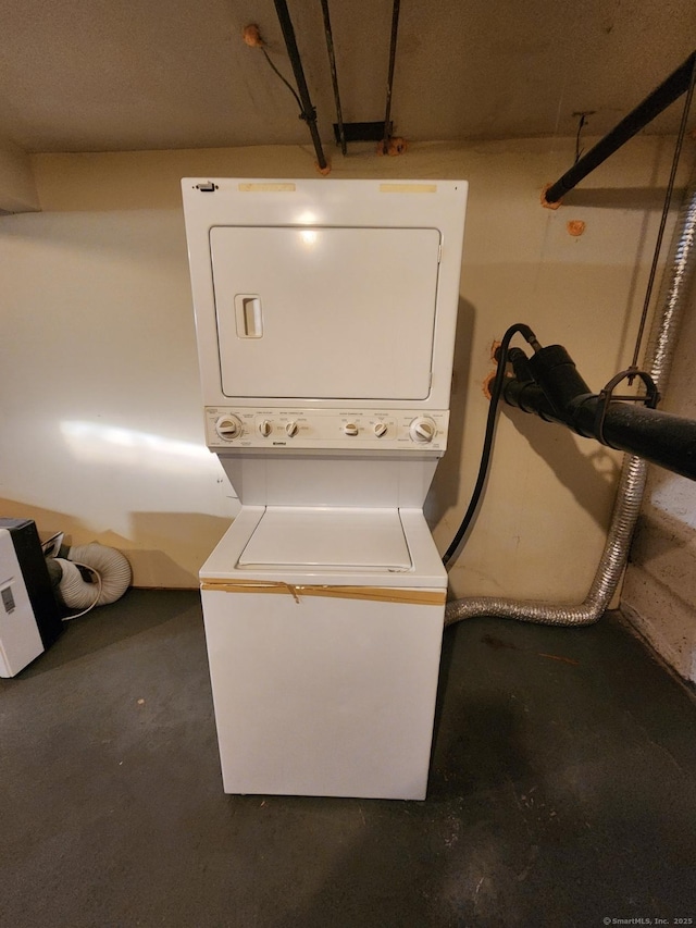 washroom featuring stacked washer / drying machine