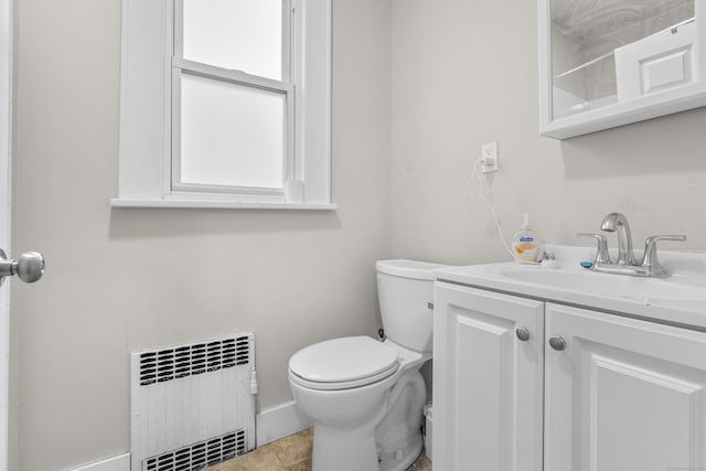 bathroom with tile patterned floors, vanity, toilet, and radiator