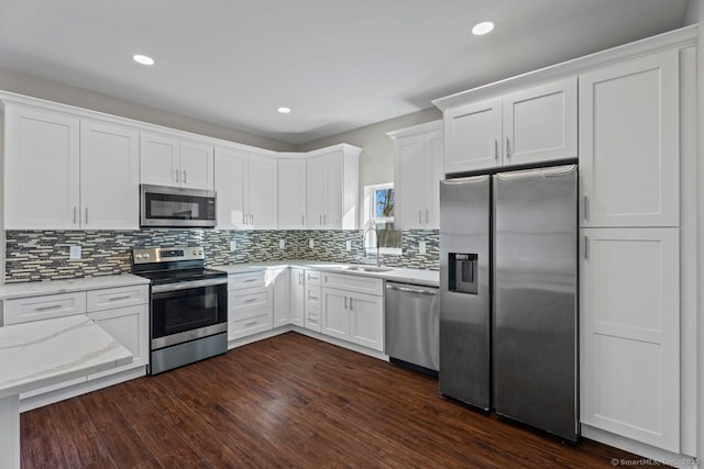 kitchen with stainless steel appliances, dark hardwood / wood-style flooring, sink, and white cabinets