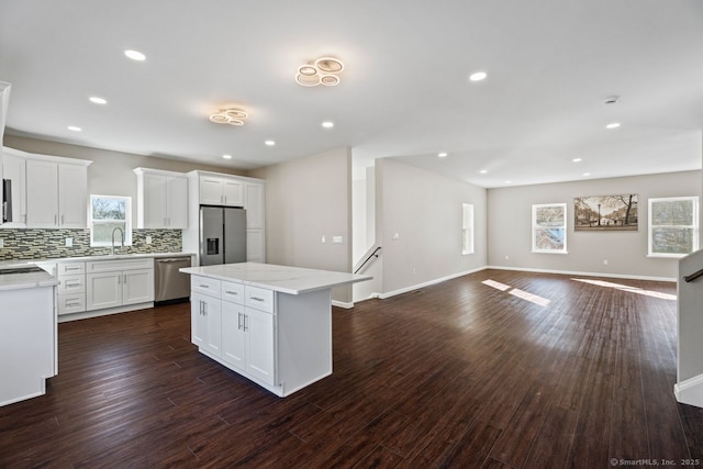 kitchen with a kitchen island, white cabinetry, appliances with stainless steel finishes, and sink