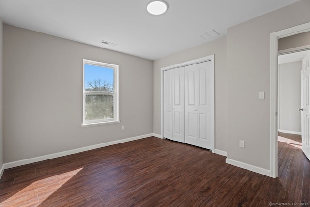 unfurnished bedroom featuring a closet and dark hardwood / wood-style floors