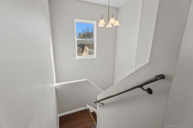 stairway with an inviting chandelier and hardwood / wood-style floors