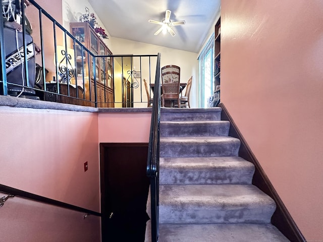 stairway with lofted ceiling and ceiling fan