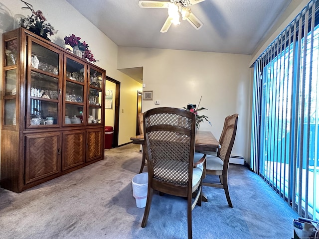 dining space with lofted ceiling, a baseboard heating unit, light carpet, and ceiling fan