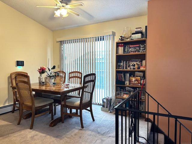 dining space featuring a textured ceiling, carpet floors, and ceiling fan