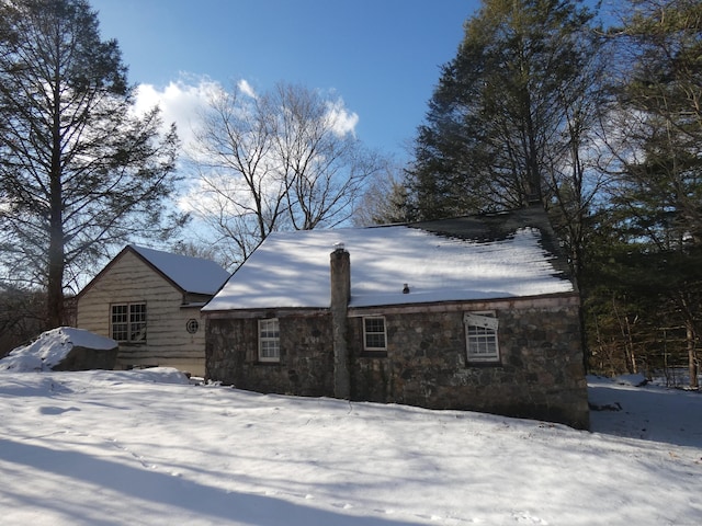 view of snow covered back of property