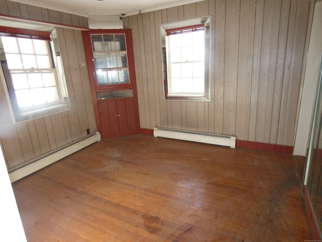 interior space with a baseboard radiator, dark hardwood / wood-style floors, and wooden walls