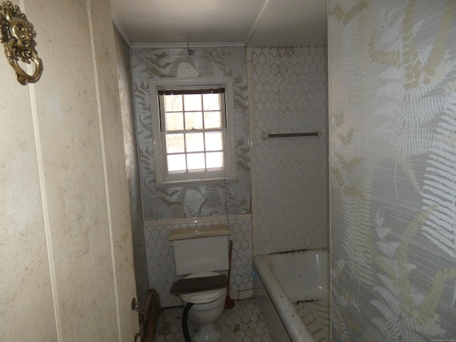 bathroom featuring tile patterned floors, toilet, and a washtub