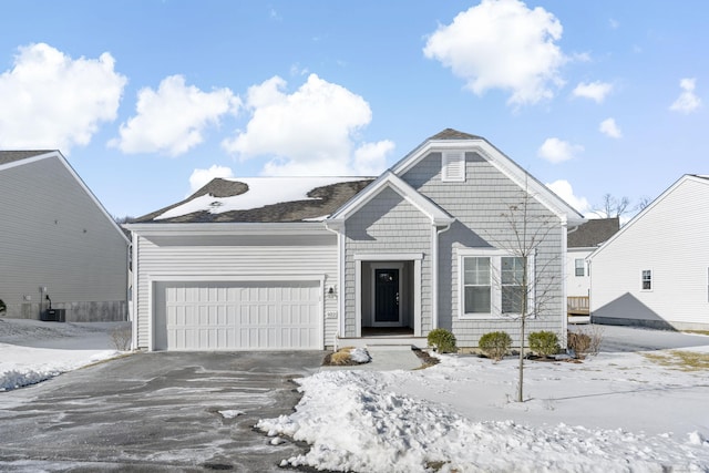 view of front of home with a garage and central air condition unit