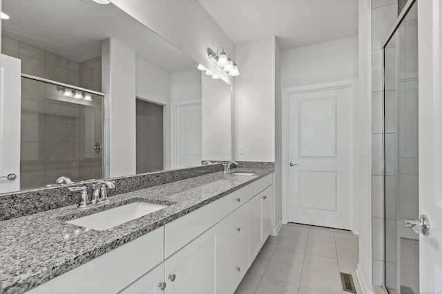 bathroom with tile patterned flooring, vanity, and a shower with shower door