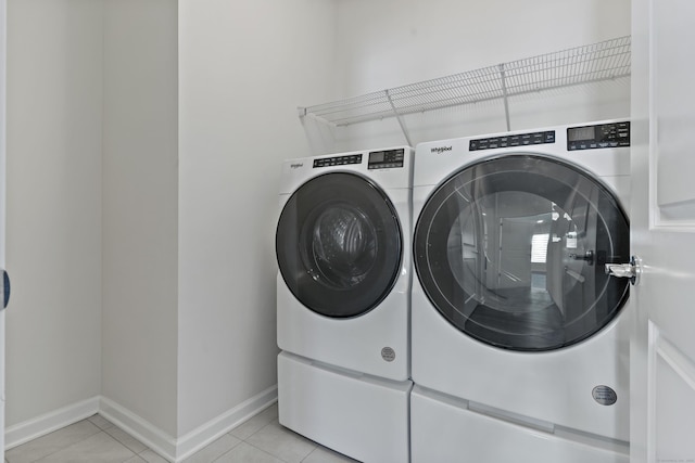 laundry room with light tile patterned flooring and washer and dryer