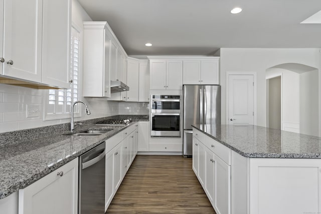 kitchen featuring white cabinetry, sink, stone counters, and appliances with stainless steel finishes