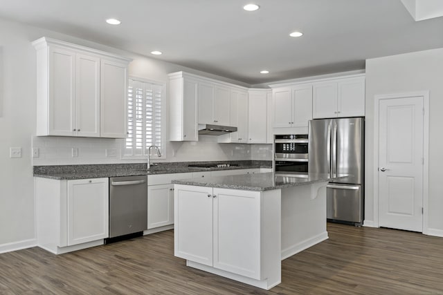 kitchen featuring dark stone countertops, stainless steel appliances, and white cabinets