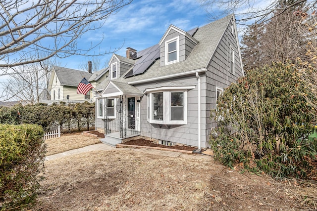 new england style home featuring solar panels