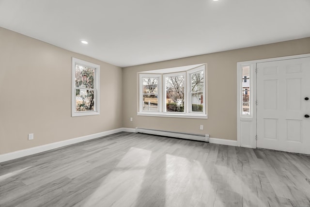 entryway featuring a baseboard heating unit and light hardwood / wood-style floors