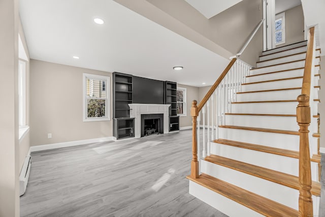 stairs with a baseboard radiator and wood-type flooring