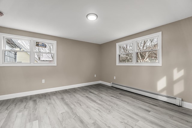 spare room with a baseboard radiator and light wood-type flooring