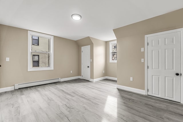 spare room featuring a baseboard radiator and light hardwood / wood-style flooring