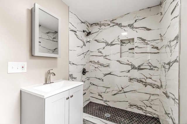 bathroom with vanity and tiled shower