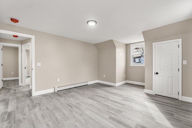 additional living space with a baseboard radiator and light hardwood / wood-style floors