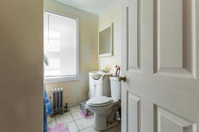 bathroom with radiator heating unit, toilet, tile patterned flooring, and vanity