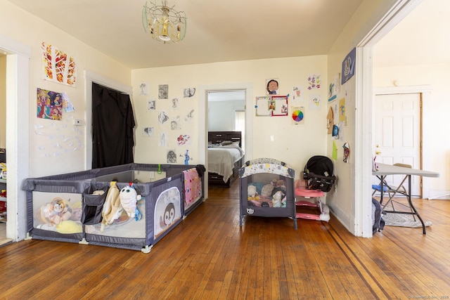 bedroom with dark wood-type flooring and a chandelier