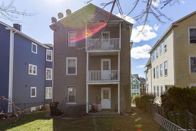 view of front facade featuring a balcony and a front lawn