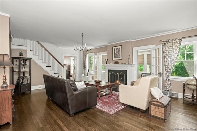 living room featuring crown molding, dark wood-type flooring, and a chandelier