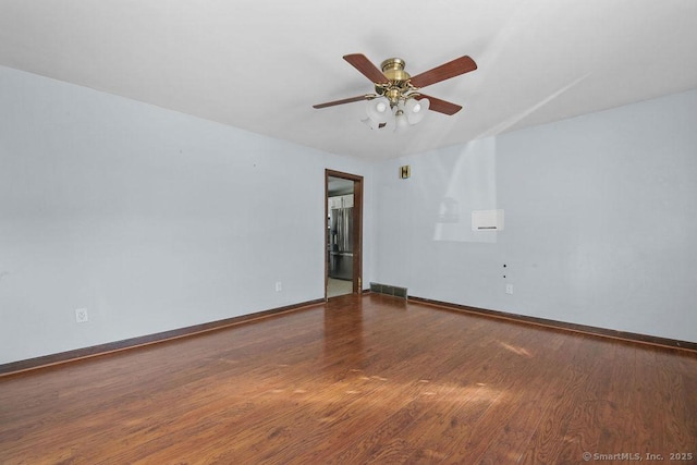 spare room featuring ceiling fan and dark hardwood / wood-style flooring