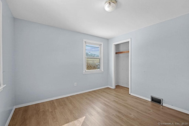 unfurnished bedroom featuring a closet and light wood-type flooring