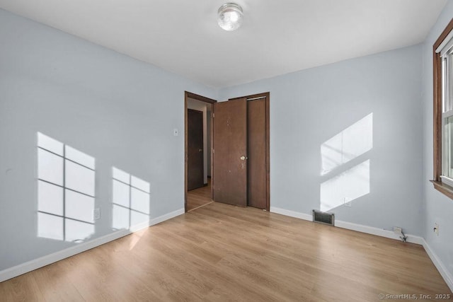 spare room with a healthy amount of sunlight and light hardwood / wood-style flooring