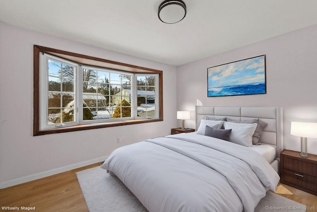 bedroom with multiple windows and light hardwood / wood-style floors