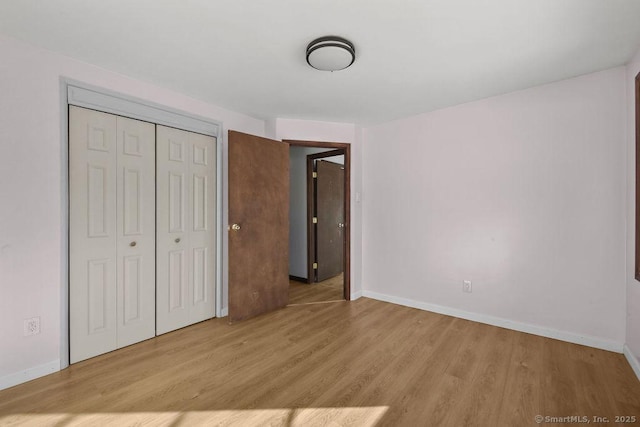 unfurnished bedroom featuring light hardwood / wood-style floors and a closet