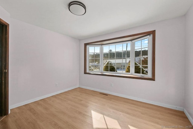 unfurnished room with light wood-type flooring