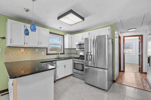 kitchen with sink, white cabinetry, stainless steel appliances, tasteful backsplash, and kitchen peninsula