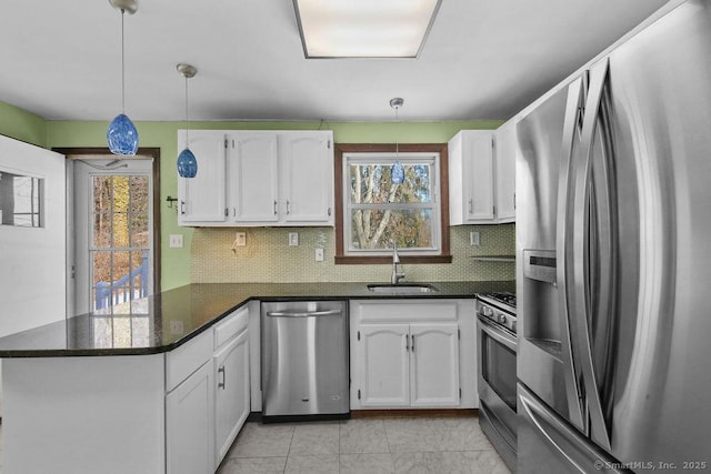 kitchen with appliances with stainless steel finishes, pendant lighting, white cabinetry, sink, and kitchen peninsula