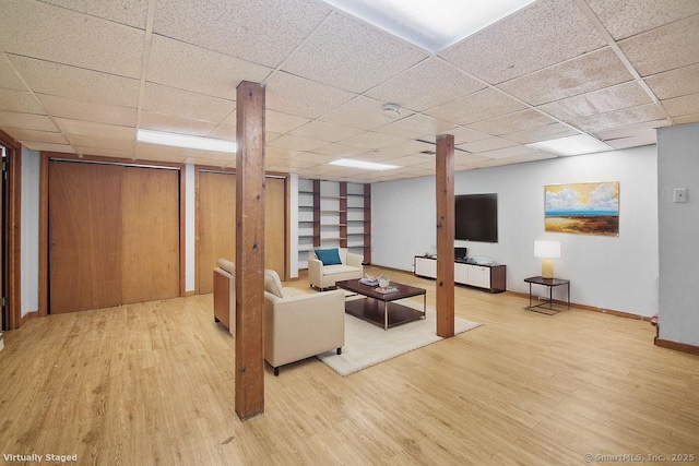 living room featuring hardwood / wood-style flooring and a drop ceiling